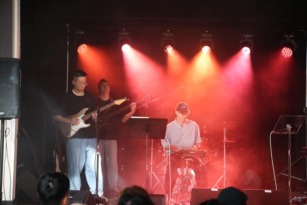 Guitarist and vocalist performing under a dramatic red and orange light wash